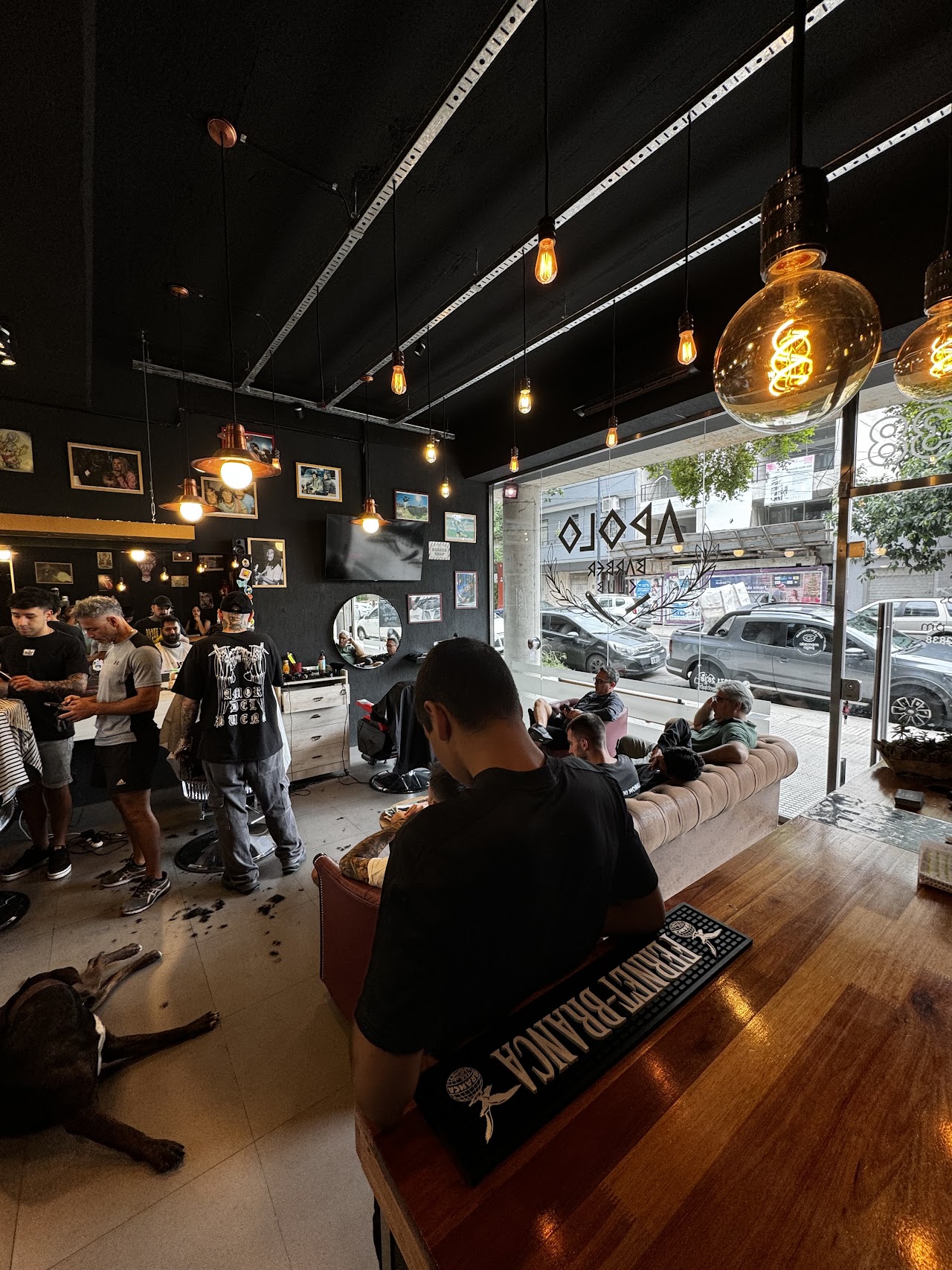 Interior de Apolo Barber Club con sillones y clientes